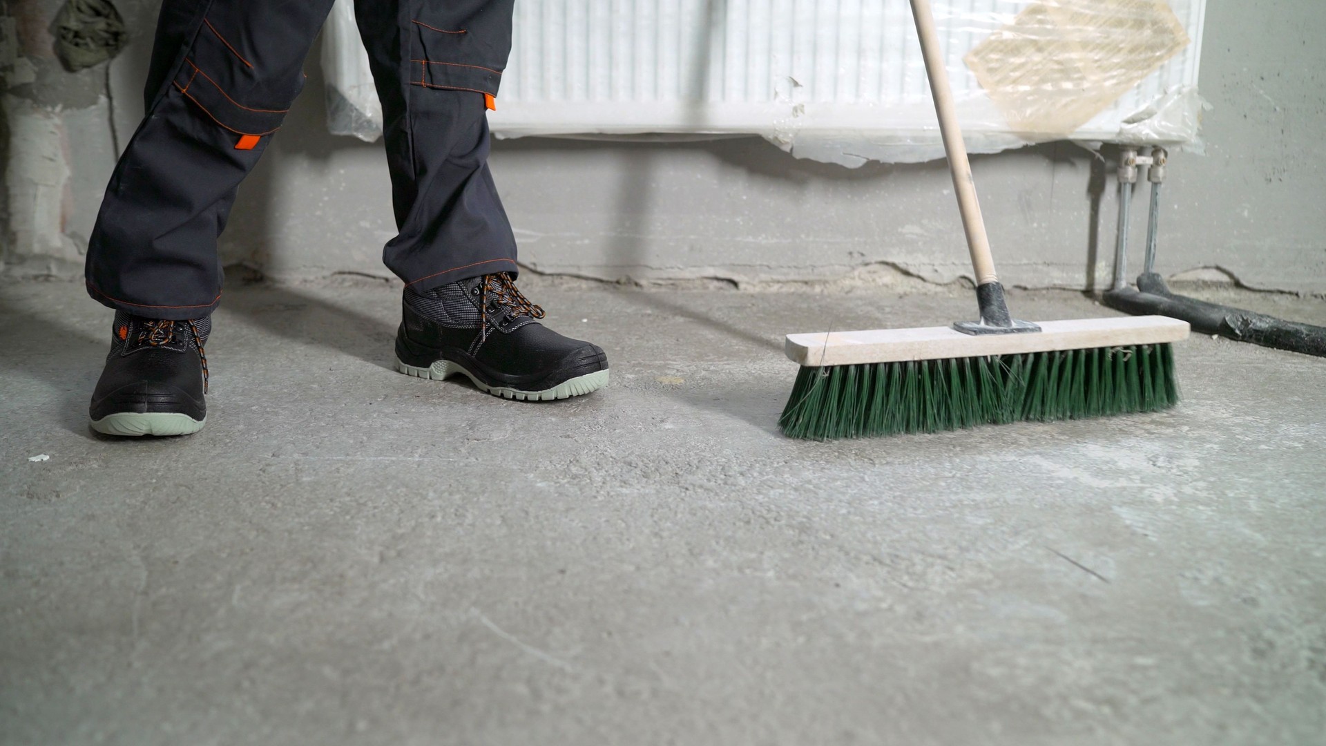 Worker cleaning industrial dirt. Worker with a floor brush.